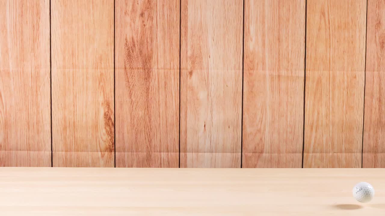 골프 공이 나무 표면을 가로질러 굴러