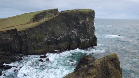 Eine-Atemberaubende-Valahnúkamöl-Klippe-Am-Meer-Mit-Wellen,-Die-Gegen-Felsen-Schlagen-Und-Möwen,-Die-Im-Wind-Gleiten