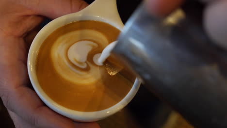 server does quick latte art behind the coffee counter at a diner