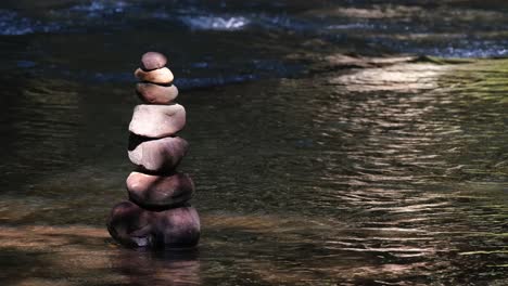 rock balancing or rock stacking at a river