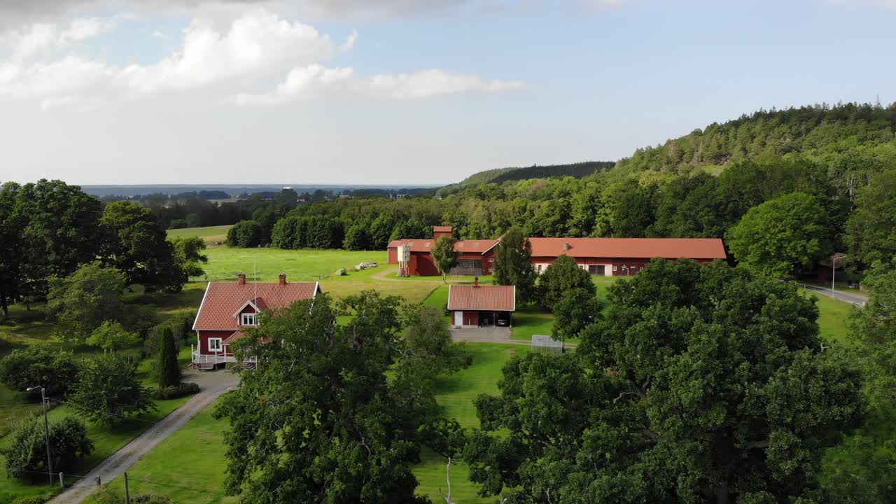Rising aerial shot of traditional Swedish red wooden houses and forest