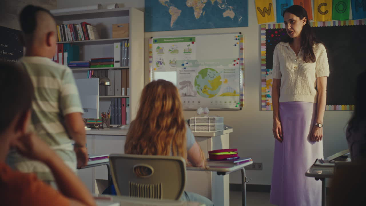 Female Teacher Calling Young Pupil to the Board During Environmental Science Lesson