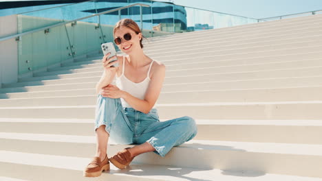 woman using phone on city stairs