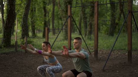 couple doing squats in the park