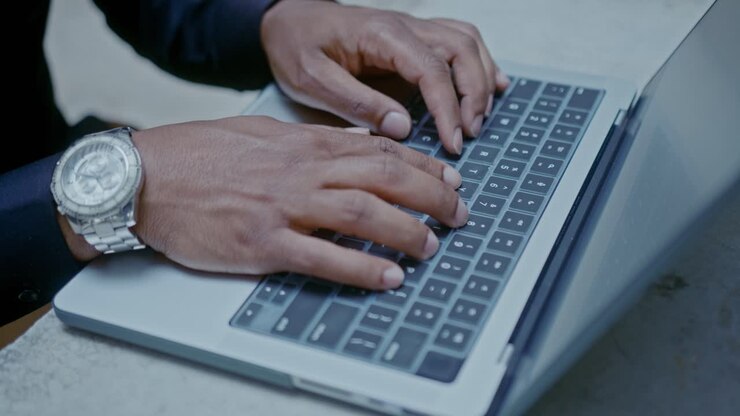 Person, die auf dem Laptop eingibt