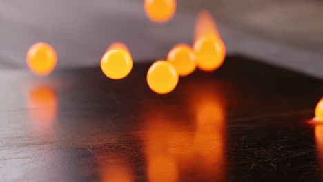 orange glowing orbs falling and splattering on dark surface