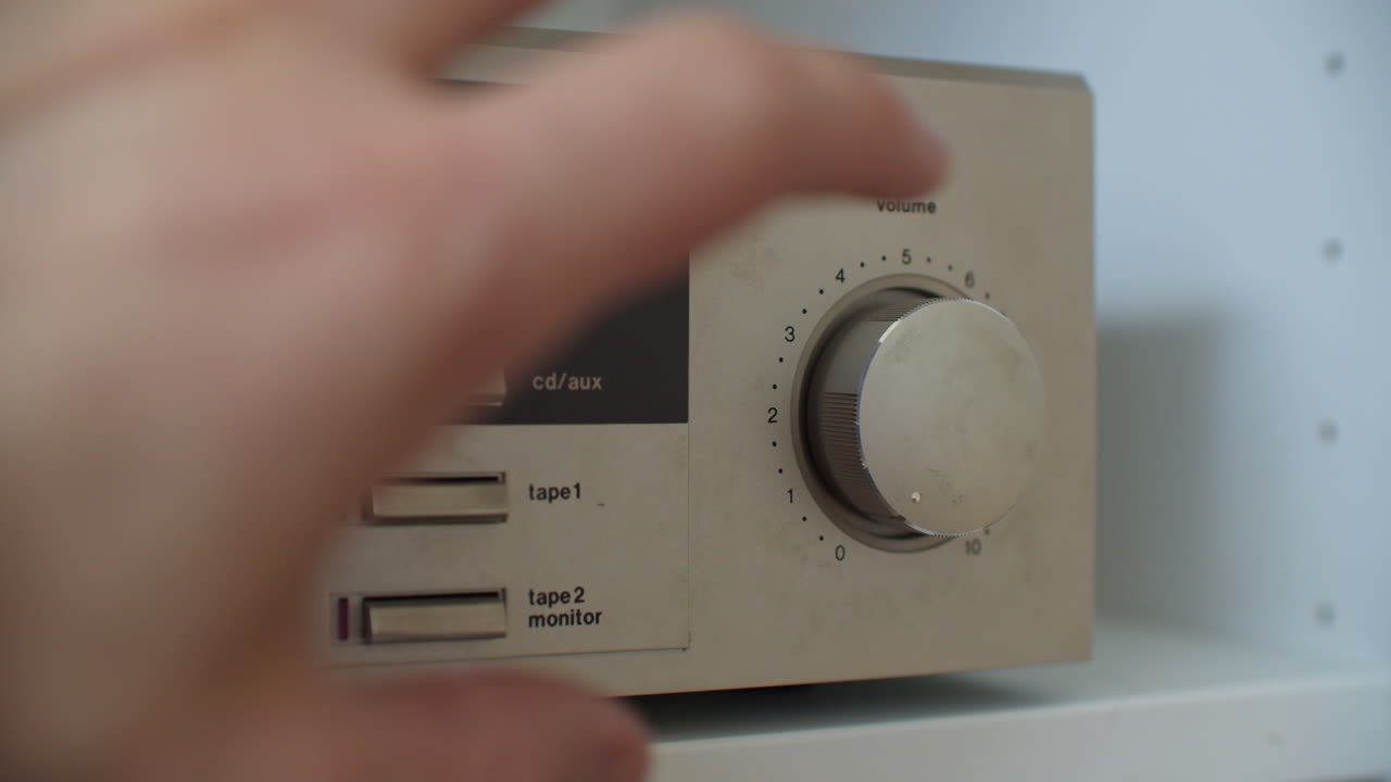 primer plano de cambiar un receptor al modo phono para vinilo y ajustar el volumen