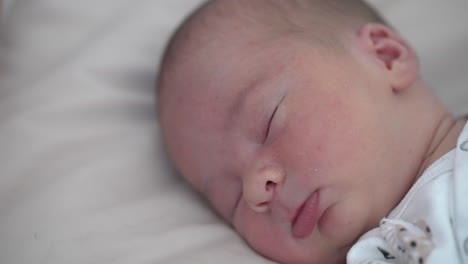 adorable infant sleeps calm on soft bed at home. facial portrait of a baby boy sleeping. healthy dream. quiet night for parents after childbirth.