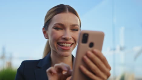 happy woman tapping smartphone at blue sky closeup. smiling manager using cell