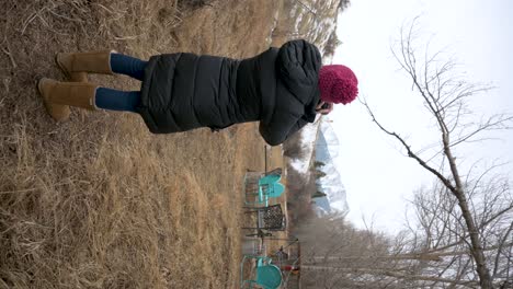 female photographer taking pictures of snow-covered mountains in a park, vertical handheld