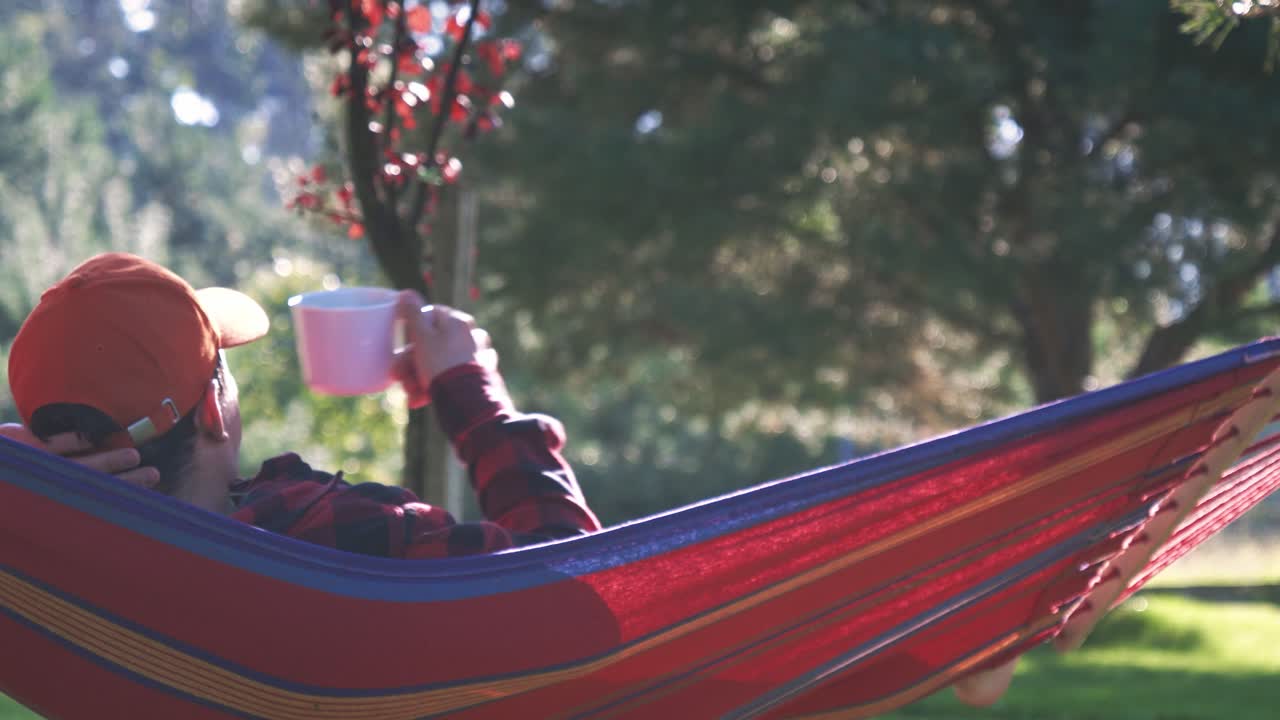 Relaxing on a hammock facing the sun and trees in Rogowko Village in Poland
