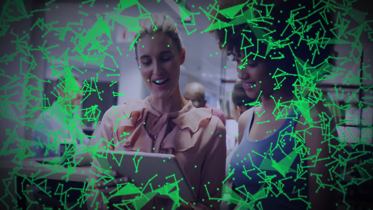 Two women collaborating on tablet in office, showing technology network overlay connecting data