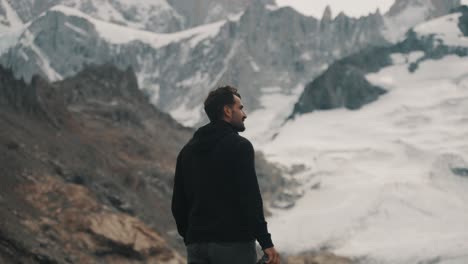 Hiker-Looking-On-Glacier-And-Rugged-Mountains-in-Los-Glaciares-National-Park,-Santa-Cruz,-Argentina