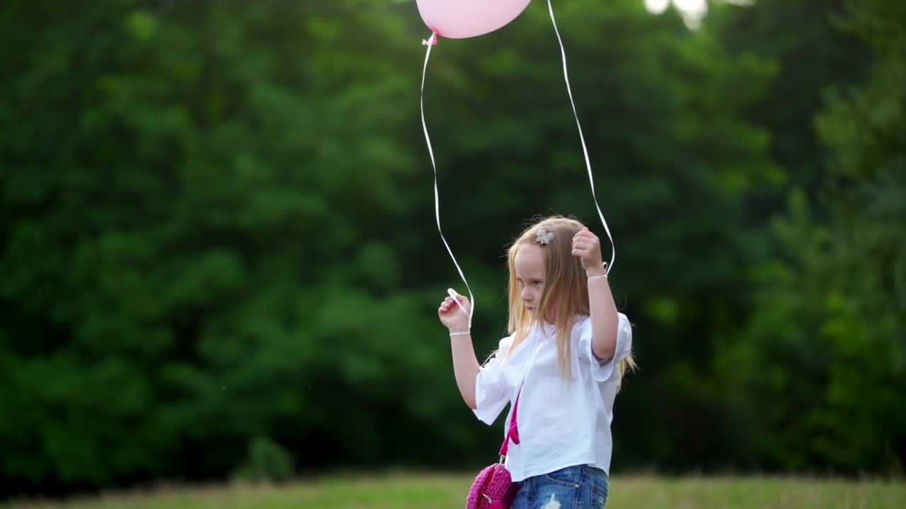 Girl with balloons on nature. Young girl holding colorful balloons in park