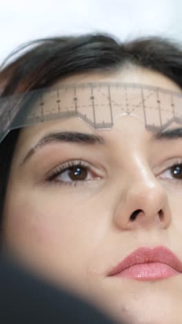 close-up of a woman's eyebrows being measured for a beauty treatment