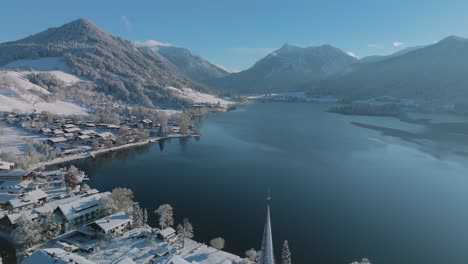 paisaje de invierno de nieve blanca en el lago schliersee con montañas y agua azul oscuro