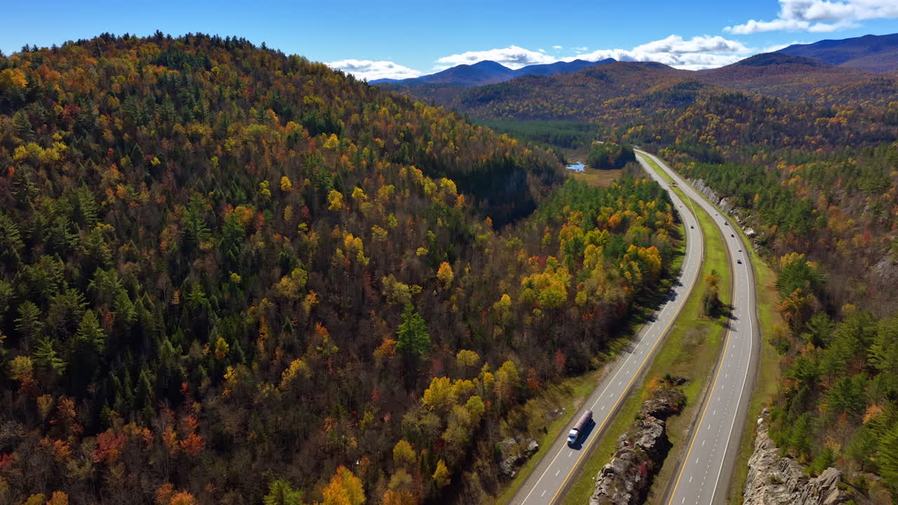 Transport rides by the highways in the mountainous area in the North New York State, USA. Sunny autumn day in nature away from cities. Top view.