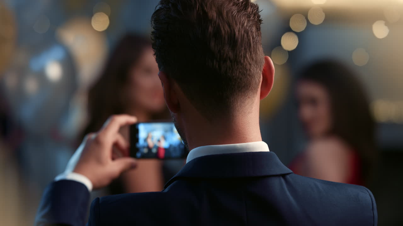 매력적인 남자가 파티에서 아름다운 여성들의 사진을 찍습니다.