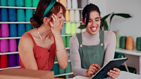 dos mujeres colaborando en un proyecto de diseño digital en una tienda de hilos