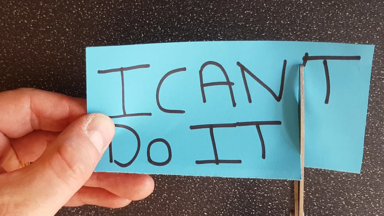 Man using scissors to remove the t from the word can't t leaving the positive motivational part. I can do it
