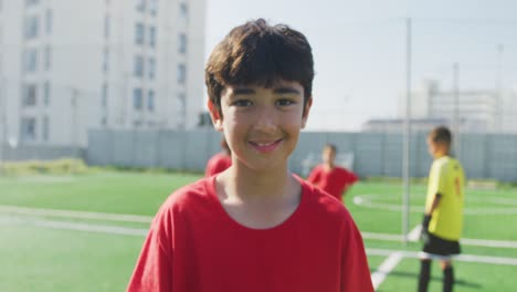 caucasian soccer kid in red smiling and looking at camera