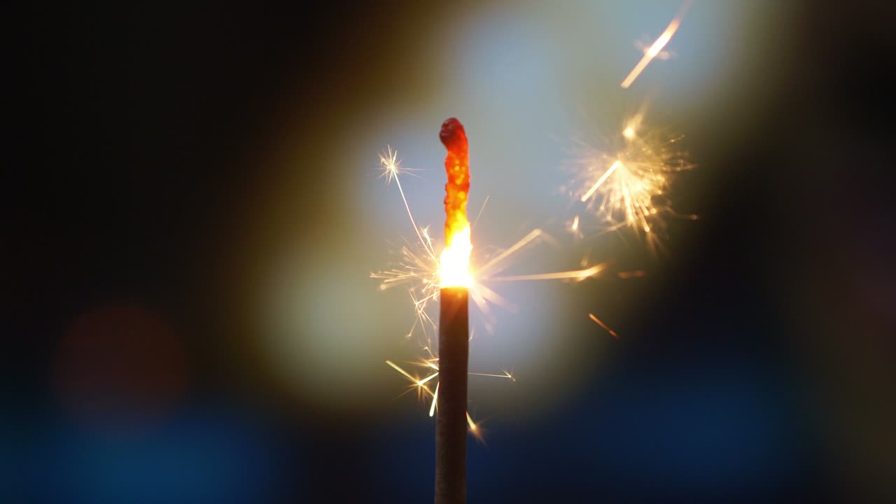 Burning bengal fire and sparks on defocused background in 4K