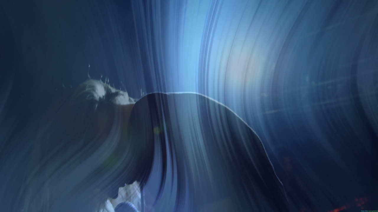 Woman bending forward on dark studio stage, featuring swirling blue lights showing technology theme