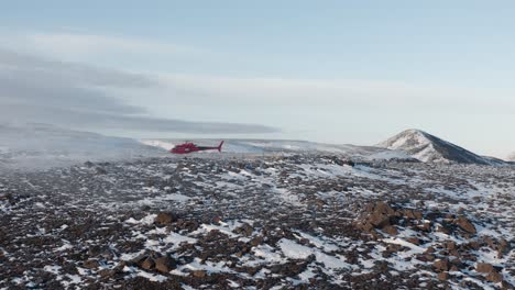 helicopter lands on snowy hill in remote arctic landscape at fagradalsfjall