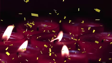 Animation-of-gold-confetti-falling-over-lit-red-candles