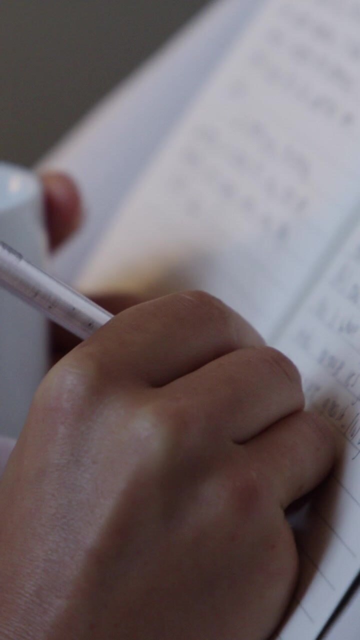 Primo piano di una persona che scrive su un quaderno