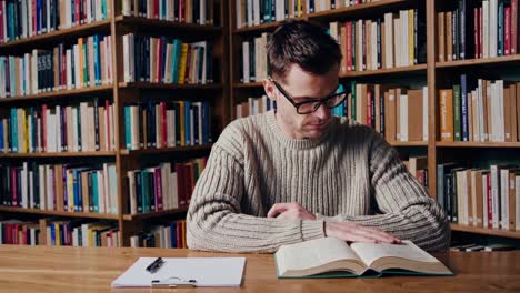 hombre leyendo en una biblioteca