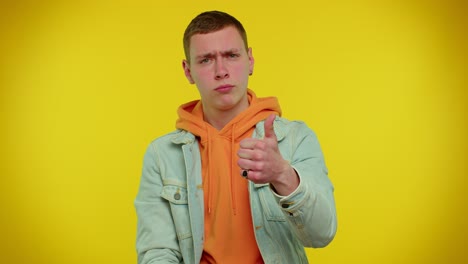 sad young man in a blue jean jacket and orange hoodie