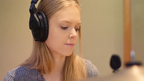 female drummer playing music on drum set