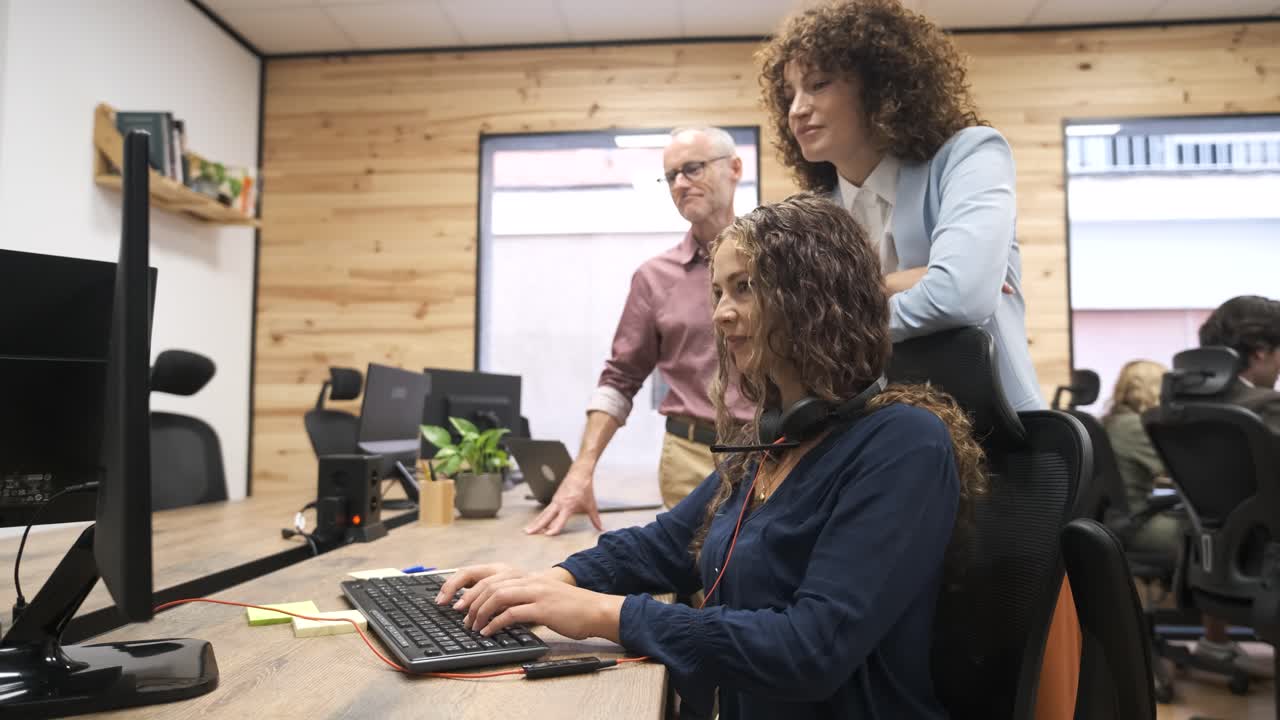 Felici colleghi che discutono di un progetto al computer in ufficio