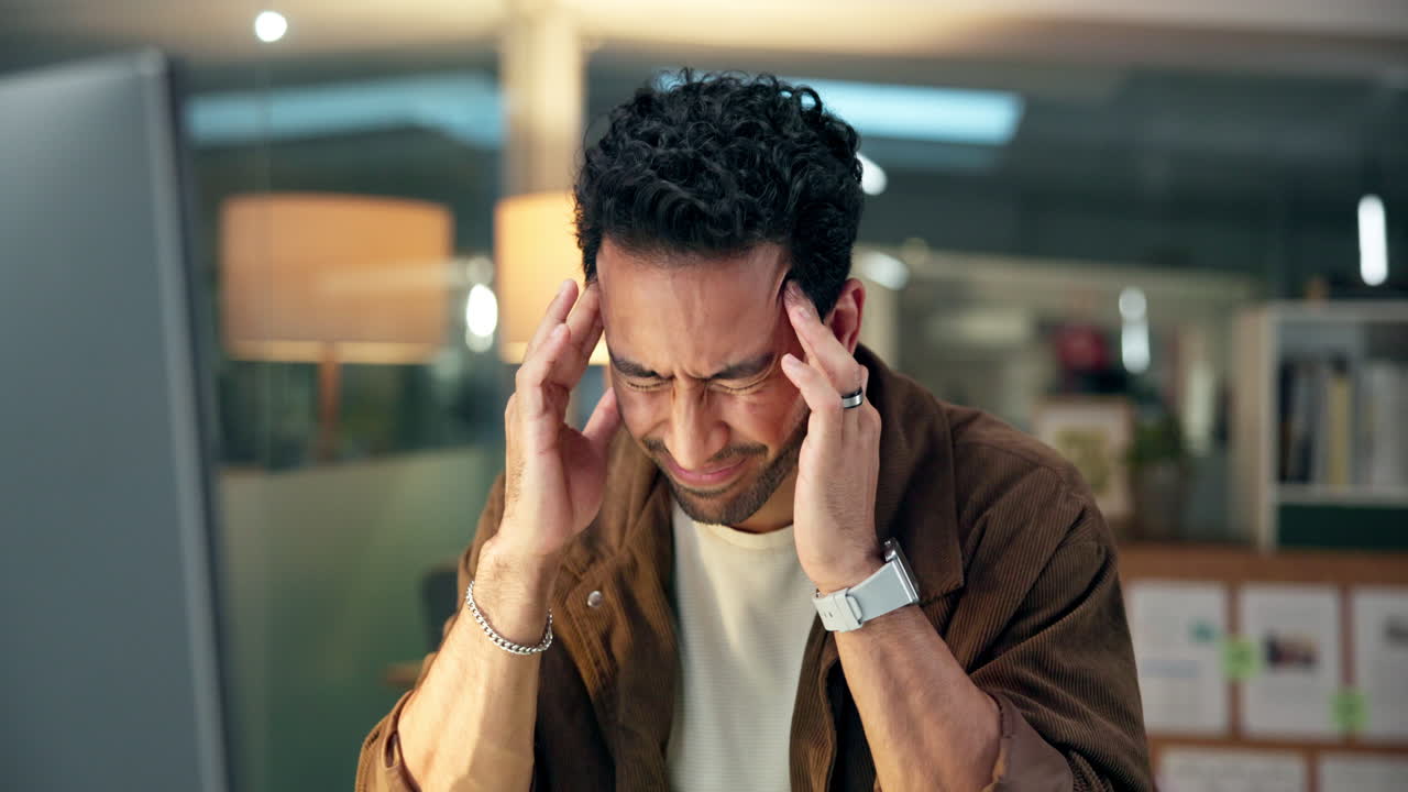 Stressed Man Suffering from Headache While Working Late in Office