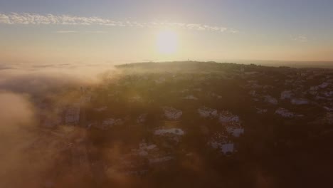 fog coming in from the atlantic ocean during sunset at luz, algarve, portugal