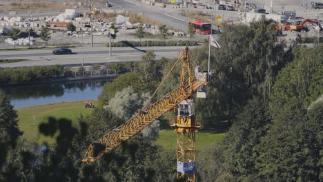 yellow hoisting crane at construction site, moving and swinging