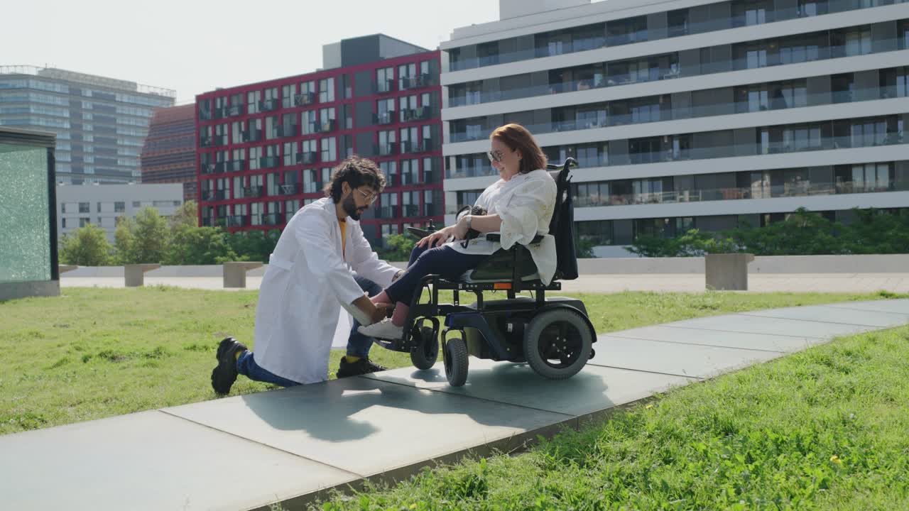 Doctor assisting a woman in a wheelchair outdoors