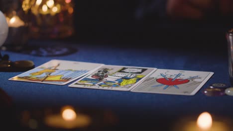 close up of woman giving tarot card reading to man on candlelit table 9