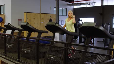 Woman-doing-exercise-on-treadmill-in-fitness-studio-4k