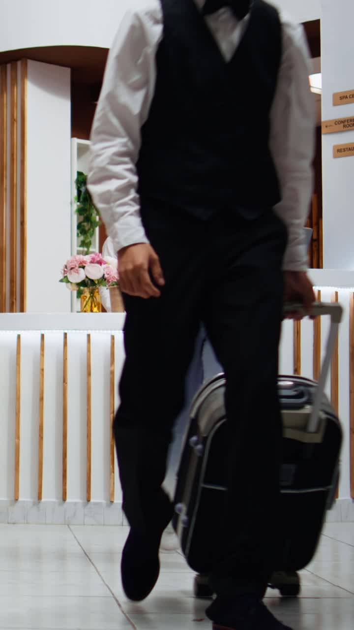 Addetto alla reception di video verticali che consegna passaporto e chiave per l'accesso alla stanza