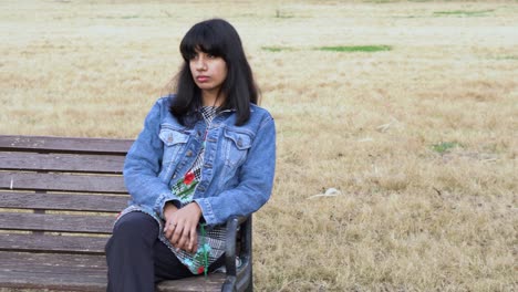 sad lonely south asian girl sitting on the bench alone