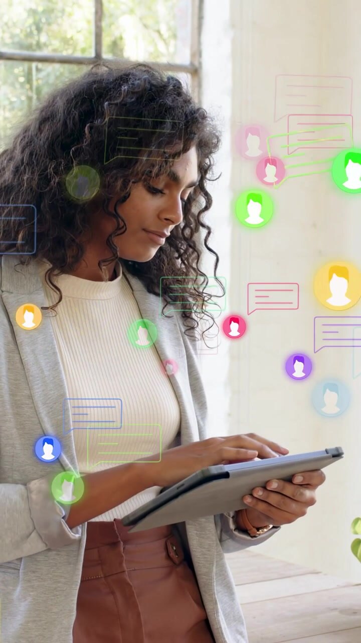 Vertical video: Woman noticing ping, tapping tablet, managing tech chats with floating icons