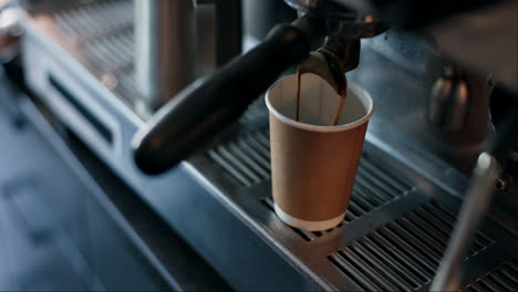 coffee being poured into a disposable cup from a coffee machine