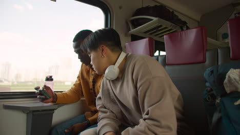 친구 들 이 열차 에서 동영상 을 보고 있다