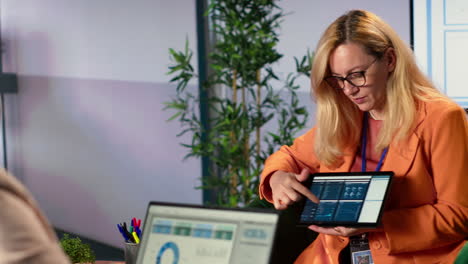 businesswoman presenting data on tablet