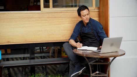 waiter using laptop and writing on notepad 4k