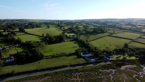 aerial view orbiting traeth coch pentraeth farmland countryside with vacation cottages along salt marsh