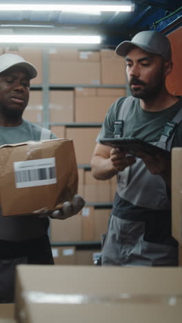 warehouse workers managing packages with tablet