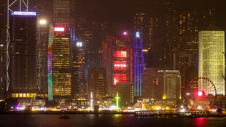 HONG KONG - 19 DE MARÇO DE 2025: Horizonte da cidade de Hong Kong Central filmado do outro lado do porto em Kowloon, com todos os arranha-céus iluminados à noite e anúncios